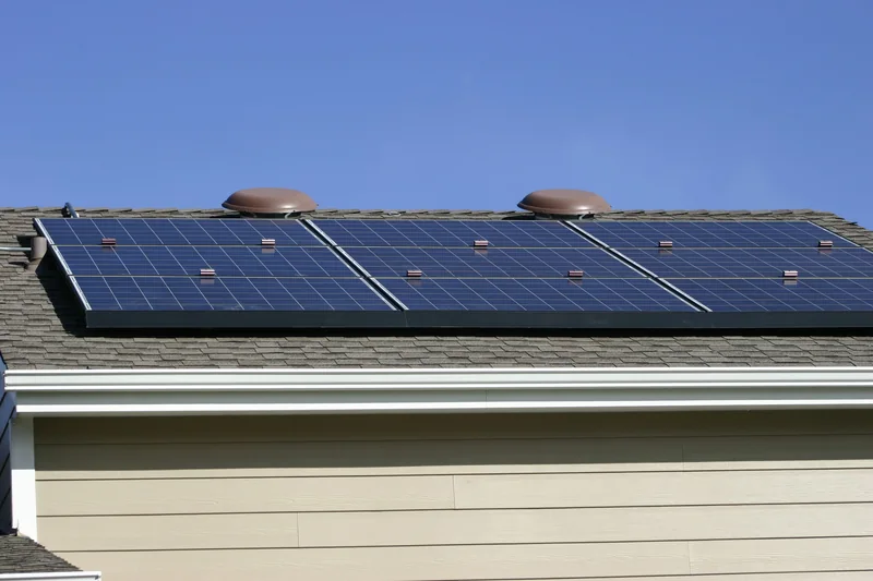 Solar panels on a residential roof under a blue sky